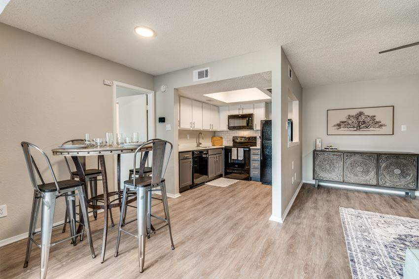 a kitchen and dining room with a bar and stools